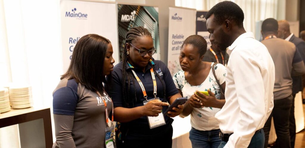 A diverse group of individuals engrossed in examining a cell phone together.