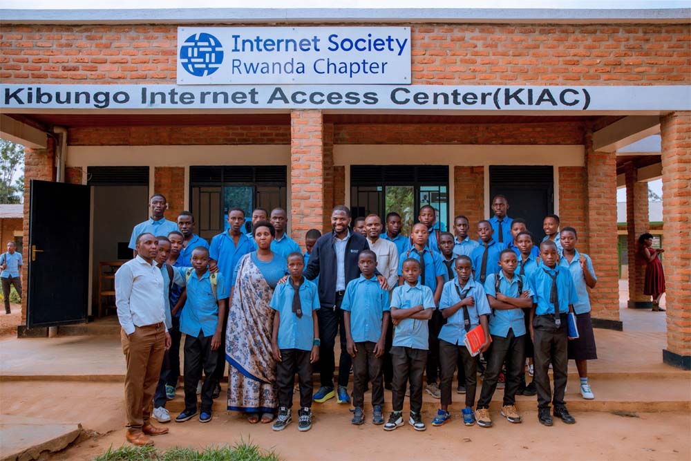 A group of children and adults stand outside an Internet Access Center in Rwanda.
