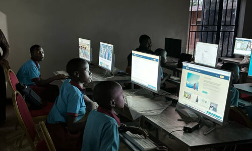 Students sit at computers.