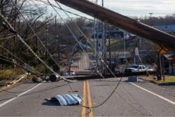 a road with power lines falling across it after a tornado has been through the area