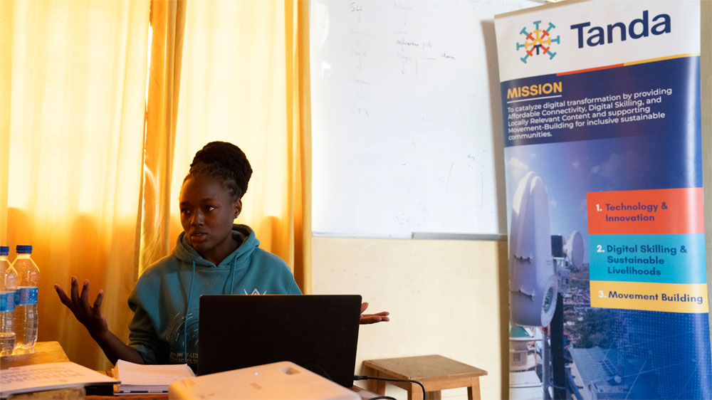 Ruth Njeri sits at a table and talks