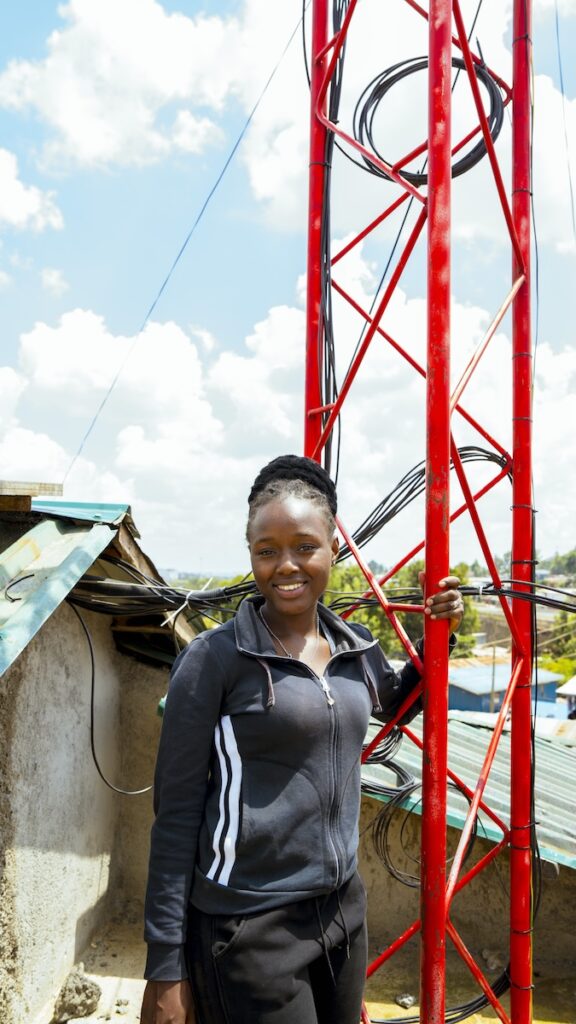 A woman stands beside a striking red tower