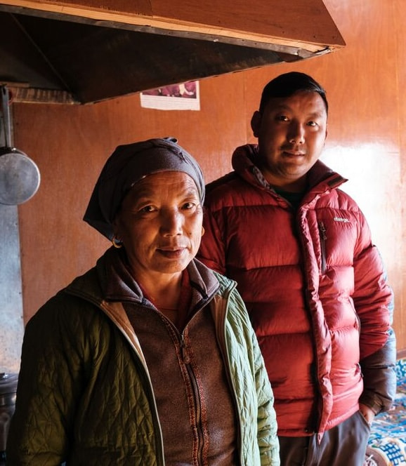 A man and woman stand together in front of a stove