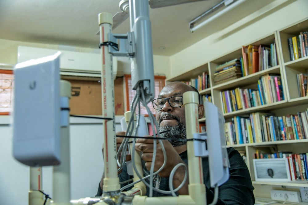 A man is engaged in assembling an antenna within a room