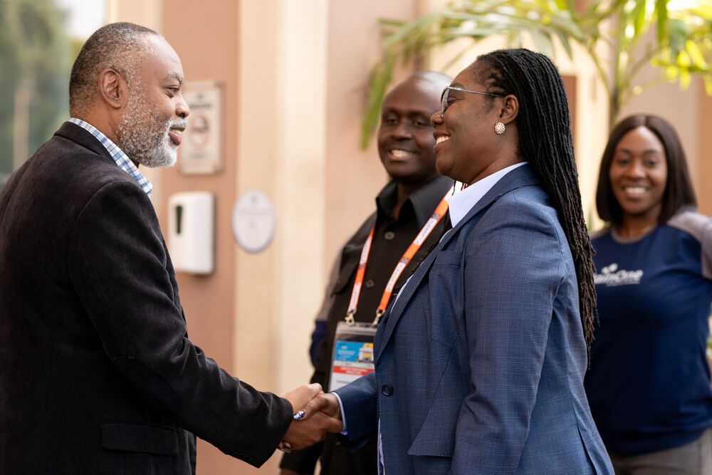 a man and a woman shake their hands smiling